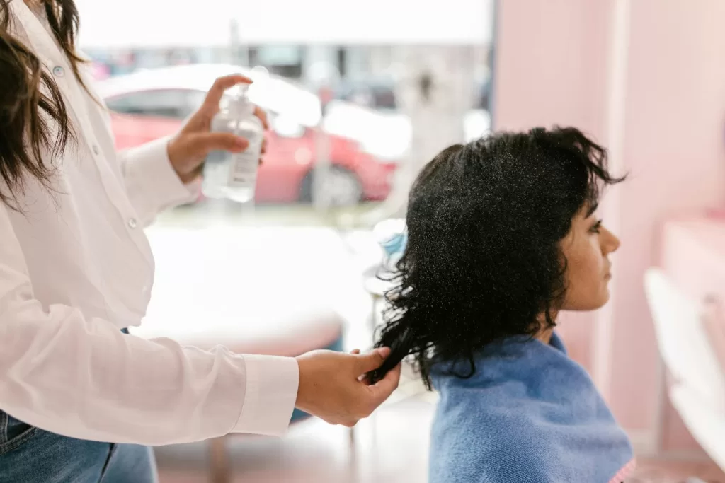 Fighting Frizz and Heat: Finding The Best Heat Protection Hair Spray in India A woman getting her hair styled at a salon, focusing on self-care and pampering.