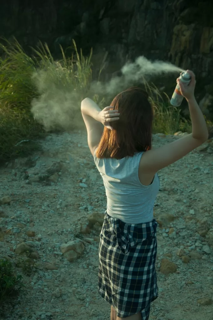 Fighting Frizz and Heat: Finding The Best Heat Protection Hair Spray in India woman in white tank top and blue plaid skirt standing on gray sand