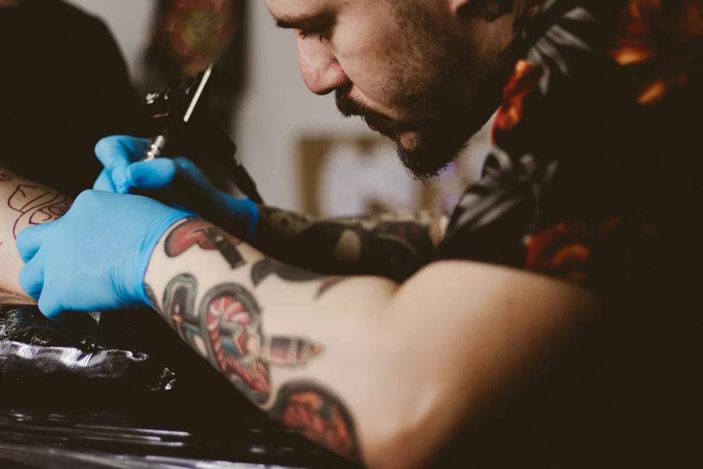 Best Tattoo Kits in India for Beginners Explained man doing tattoo on person's arm