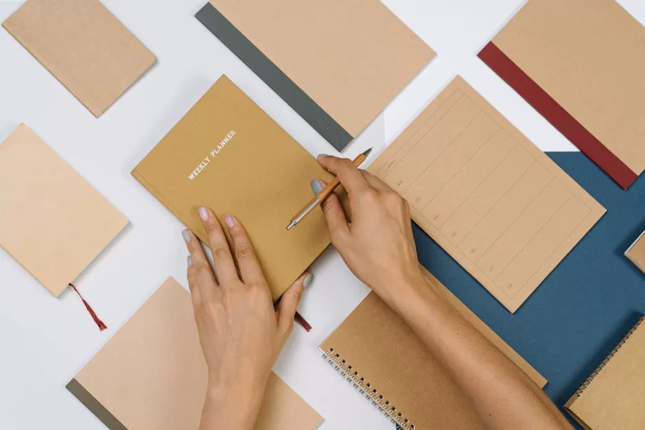 Best Address Books in India: 5 Office Picks for Reliable Contact Storage Flat lay of stationery with hands writing in a planner, showing organized care and routine maintenance of a personal address book