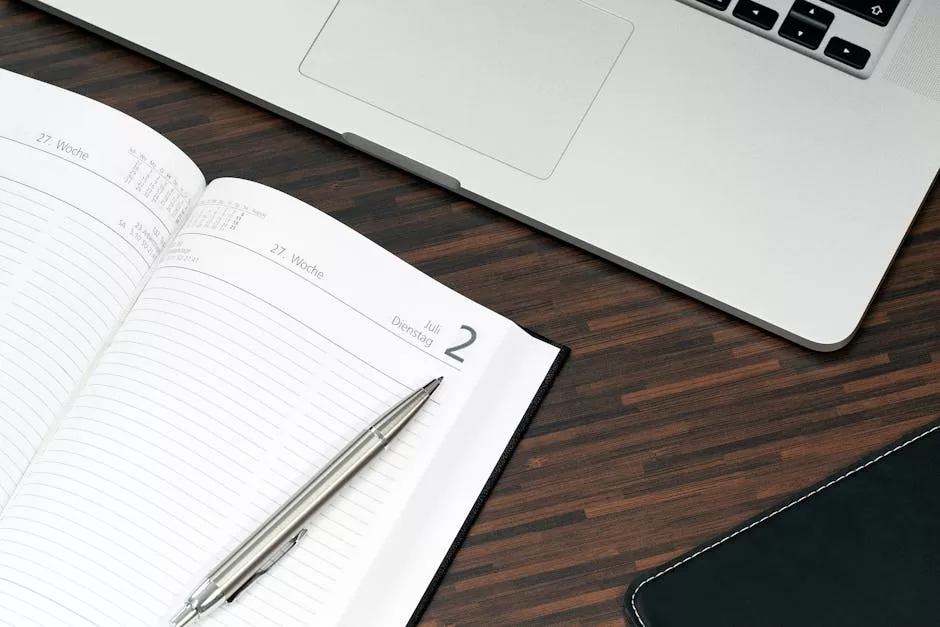 Best Address Books in India: 5 Office Picks for Reliable Contact Storage Open planner with a pen and laptop on a wooden desk, blending physical address book and digital contact workflow