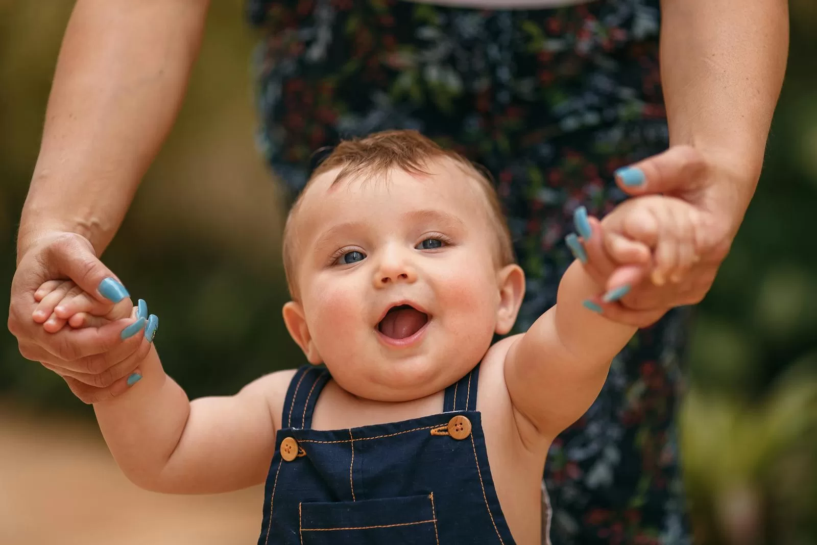 Best Baby Walkers in India: 5 Safe Picks for First Steps & Indoor Play smiling baby learning to walk holding parents hands as Indian first-time mom switches to a baby walker for early indoor mobility