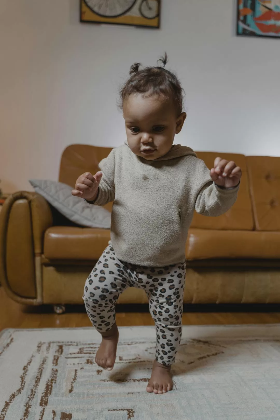 Toddler taking first independent steps on a cozy carpet at home