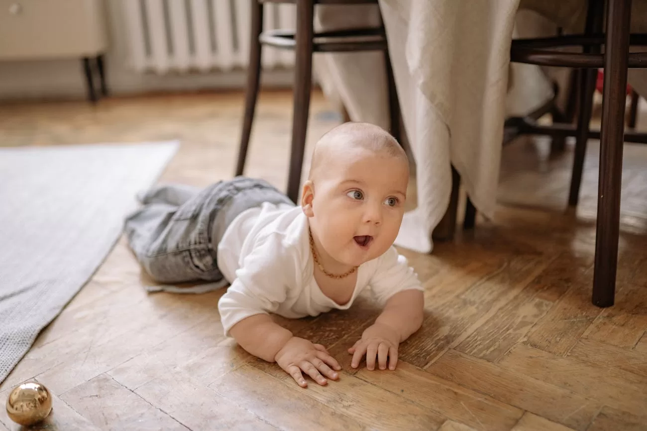 Best Door Bouncer in India: 5 Safe & Sturdy Picks for New Parents Door bouncer floor time - cute baby crawling on a wooden floor at home, free-play complement to door bouncer sessions